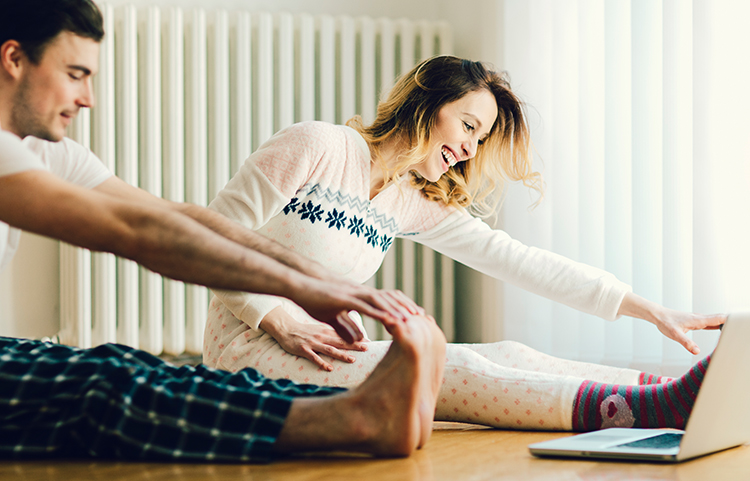 Man and woman stretching in holiday pyjamas